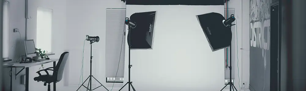 Studio photos avec éclairages, fond blanc et appareil sur trépied